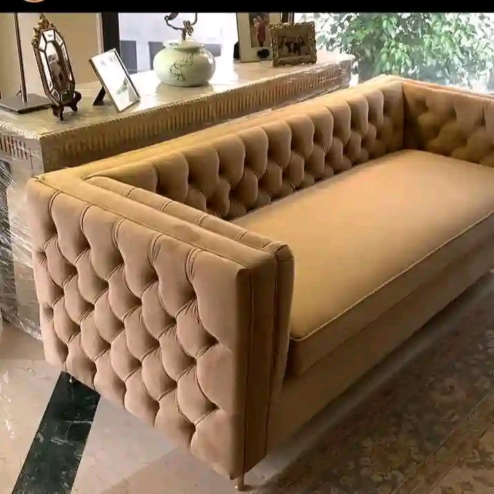 Caramel coloured sofa with deep diamond tufting across the back and arms
