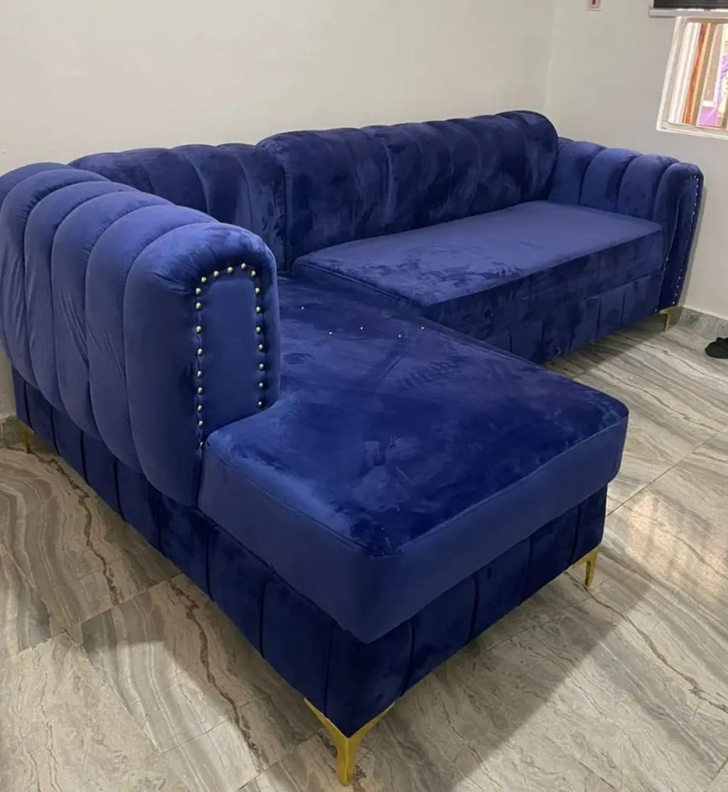 Cobalt blue velvet L-shaped sectional with channel tufting and gold feet