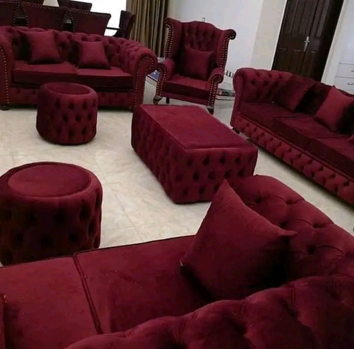 Deep red tufted sofas, chairs and matching ottomans in a living room