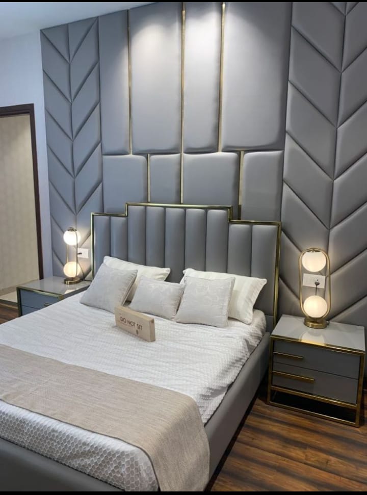 Bedroom with a full-height grey geometric upholstered headboard wall