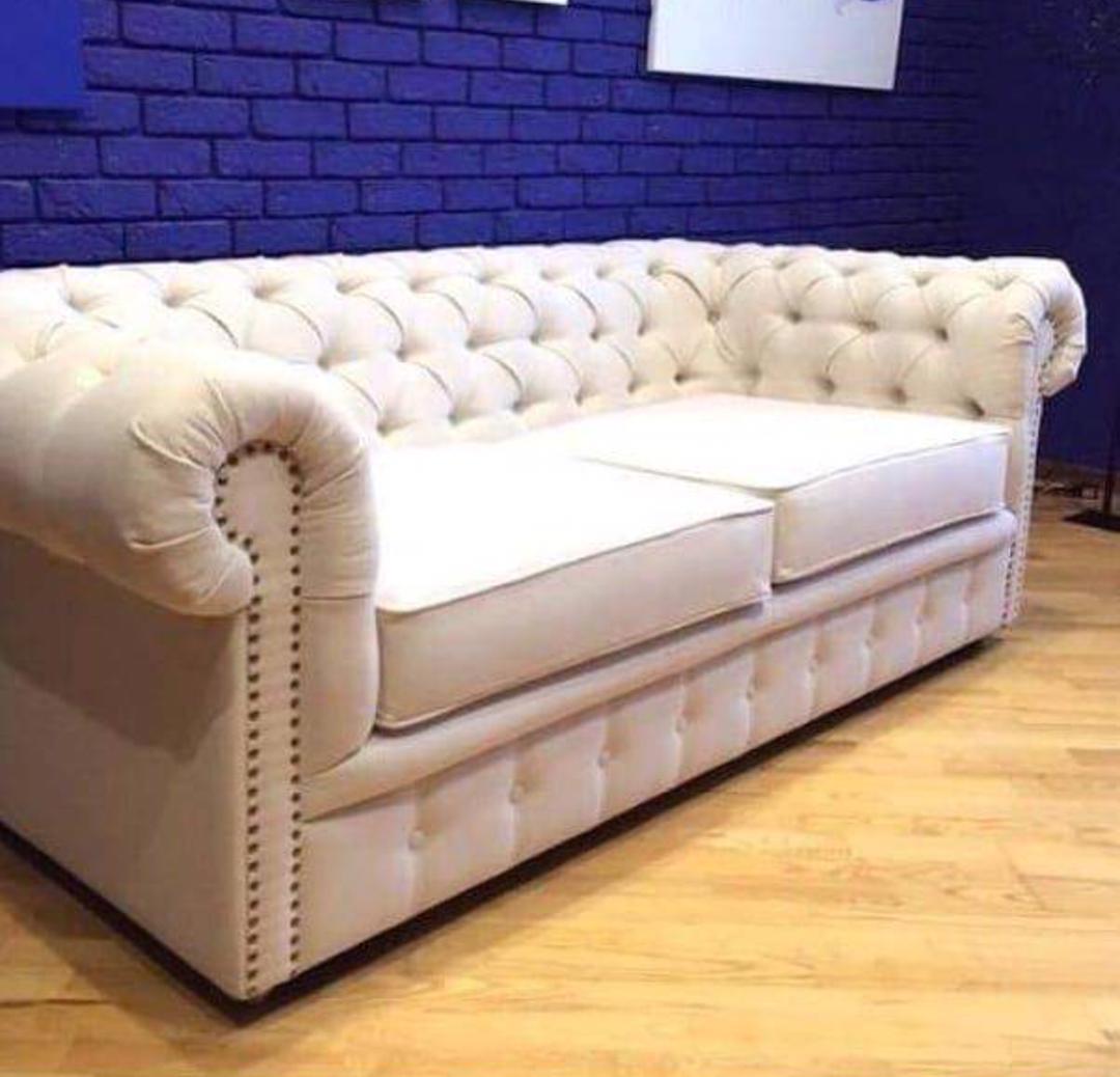 Ivory three-seat Chesterfield sofa with deep button tufting and rolled arms