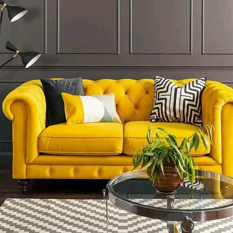 Mustard yellow velvet sofa with channel tufting and dark tapered legs