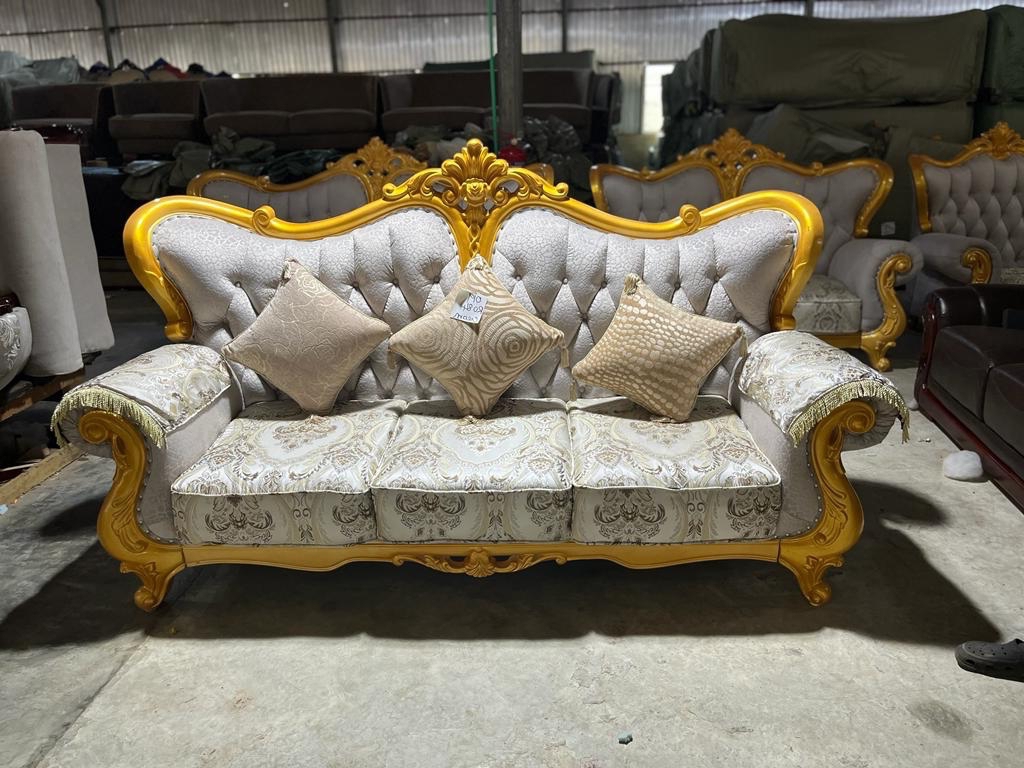 Formal cream sofa with carved gold frame and tufted upholstery
