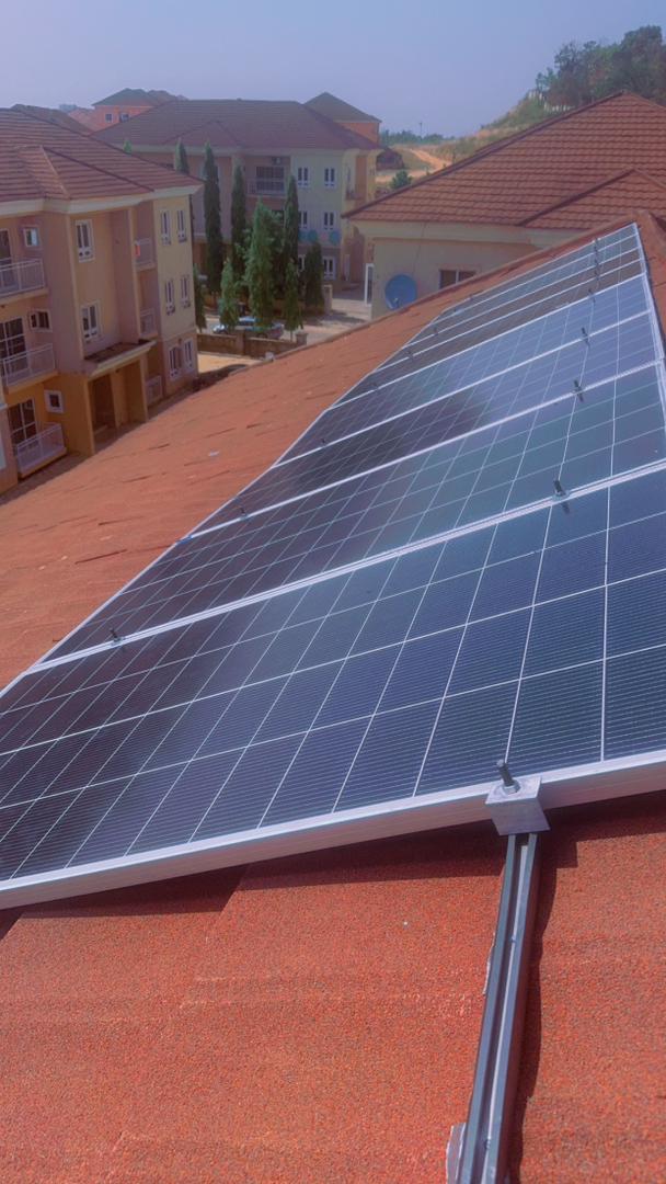 Solar photovoltaic panels mounted neatly on a red pitched residential roof