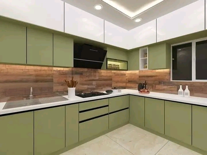 Sage green L-shaped fitted kitchen with dark worktops