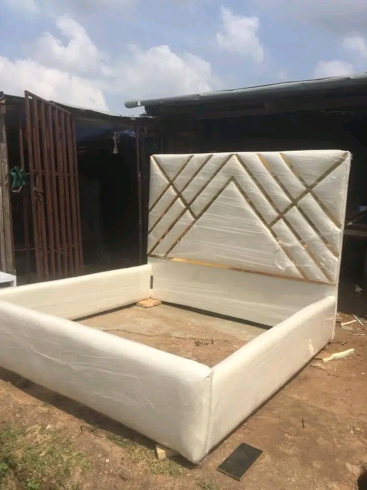 Cream upholstered bed with a tall geometric padded headboard